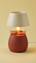 A Chestnut Spice candle warmer lamp perfectly centered in the frame, captured with a 50mm lens. The background is a softly...